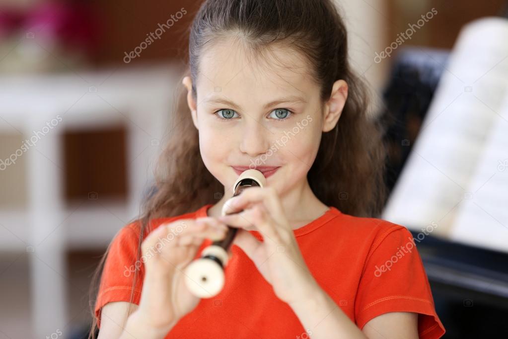 Little girl playing flute Stock Photo by ©belchonock 115189932