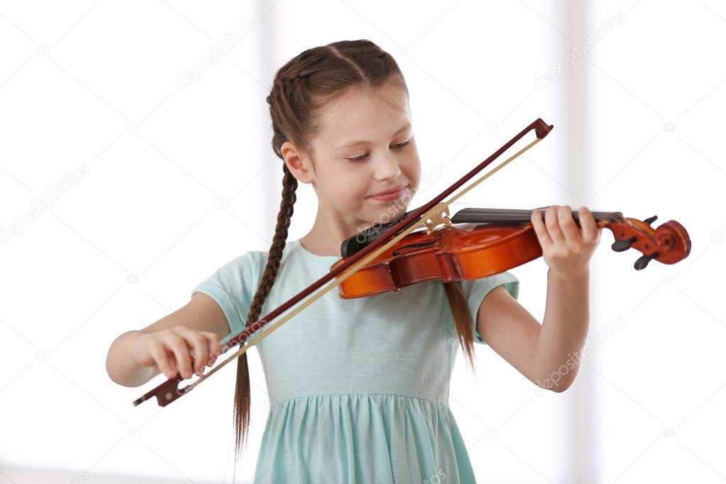 Little girl playing violin Stock Photo by belchonock 115189988