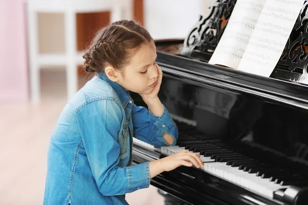 Moe meisje speelt piano — Stockfoto