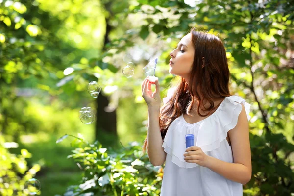 Ragazza soffiando bolle nel parco — Foto Stock