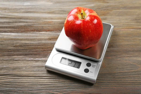 Apple с цифровыми весами на кухне — стоковое фото