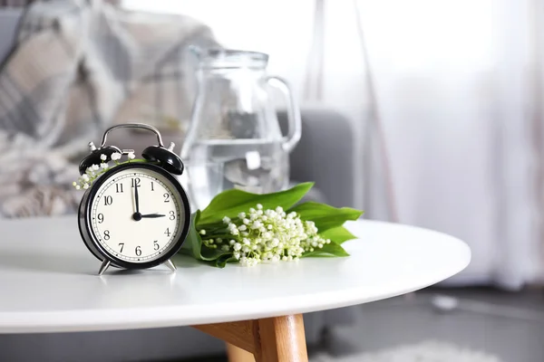 Alarm clock with lily bouquet — Stock Photo, Image