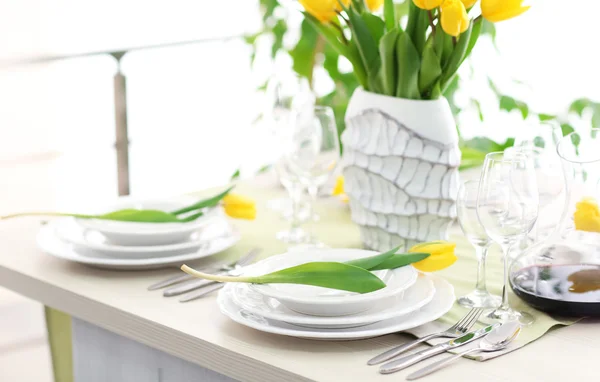 Tisch mit Geschirr und Tulpen — Stockfoto