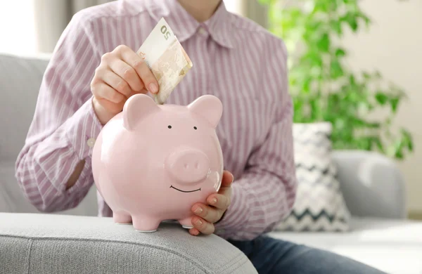 Colocar dinheiro no banco porquinho — Fotografia de Stock