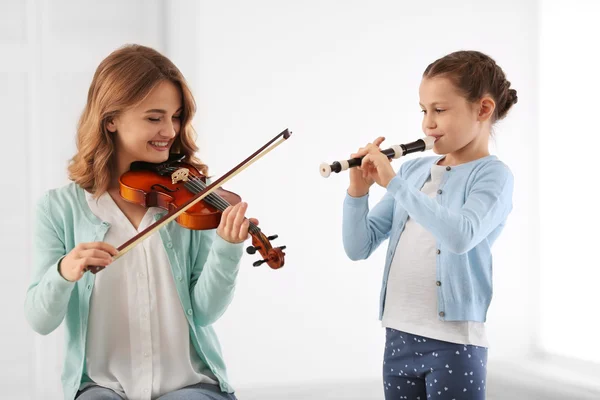 Две девушки играют на скрипке и флейте — стоковое фото