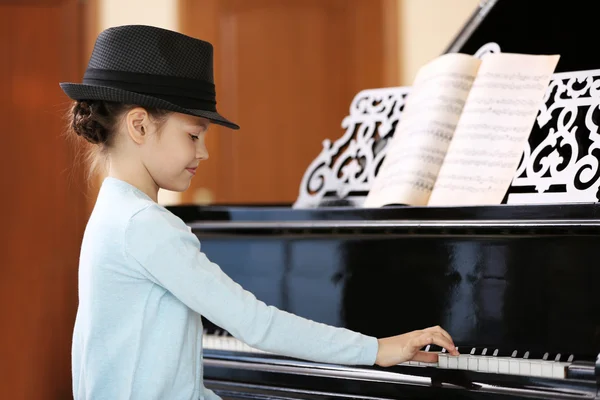 Маленькая девочка играет на пианино — стоковое фото