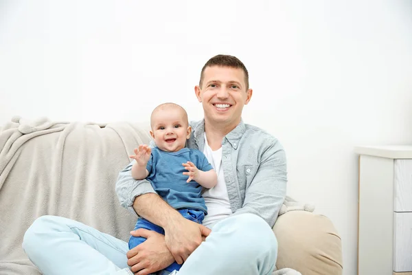 Père et bébé mignon assis sur le canapé — Photo