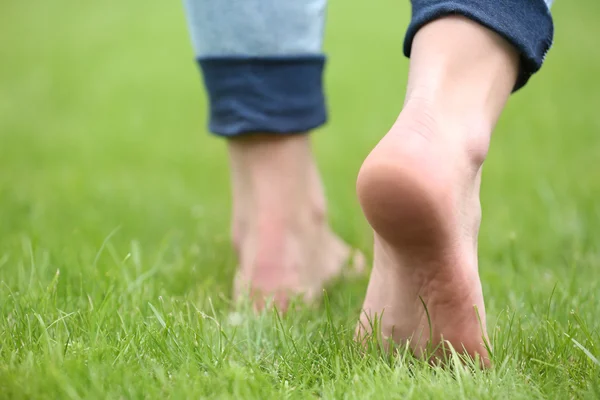 Γυναικεία πόδια σε πράσινο γρασίδι — Φωτογραφία Αρχείου