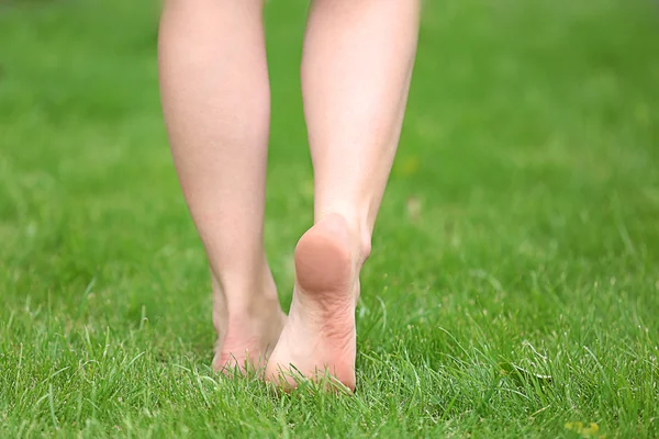 Vrouw benen op groen gras — Stockfoto