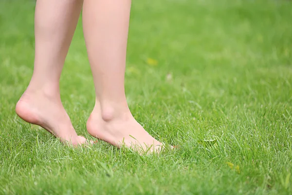 Woman legs on green grass — Stock Photo, Image