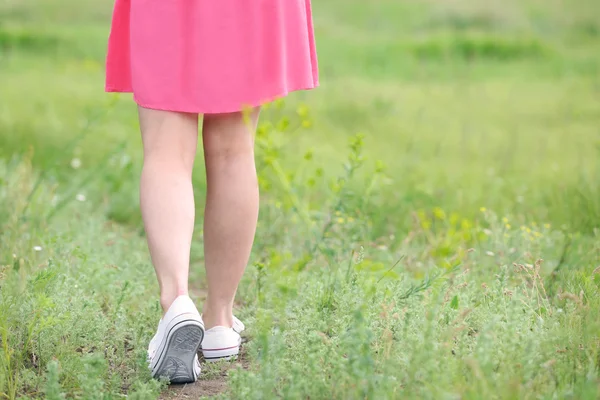 Frauenbeine auf grünem Gras — Stockfoto