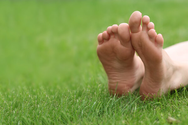 Женские ноги на зеленой траве 