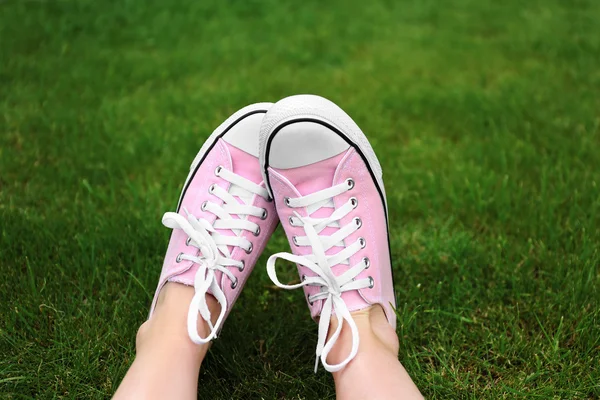 Kvinnan fötter i sneakers — Stockfoto