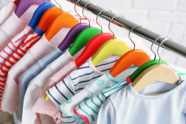 Одежда для детей на вешалках — стоковое фото