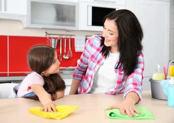 Hija y madre limpieza mesa de cocina —  Fotos de Stock