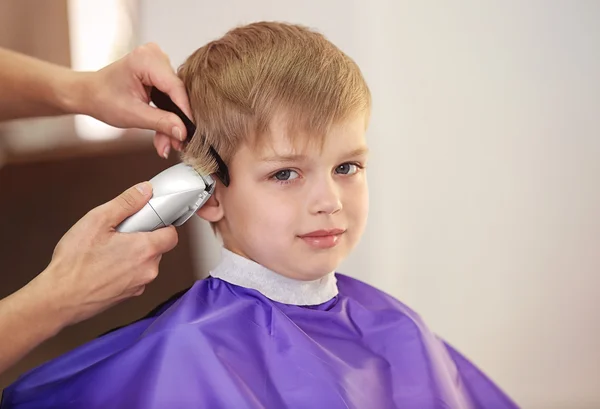 Parrucchiere rendendo l'acconciatura al bambino — Foto Stock