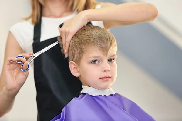 Hairdresser making hairstyle to child — Stock Photo, Image