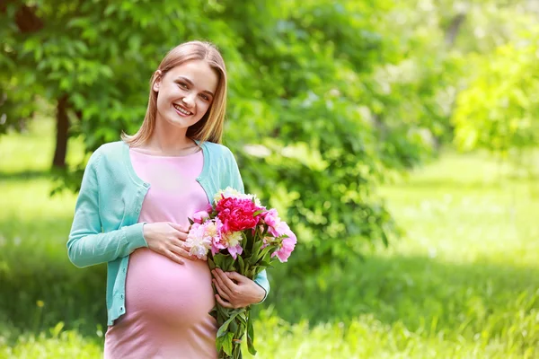 Femme enceinte tenant un bouquet de pivoine — Photo