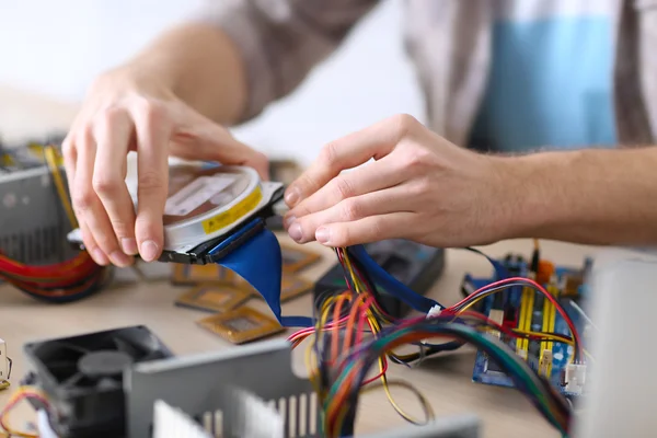 Молодой человек ремонтирует компьютерное оборудование — стоковое фото