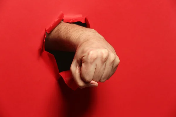 Puño masculino perforando a través de papel — Foto de Stock