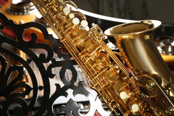 Saxophone lying on piano — Stock Photo, Image