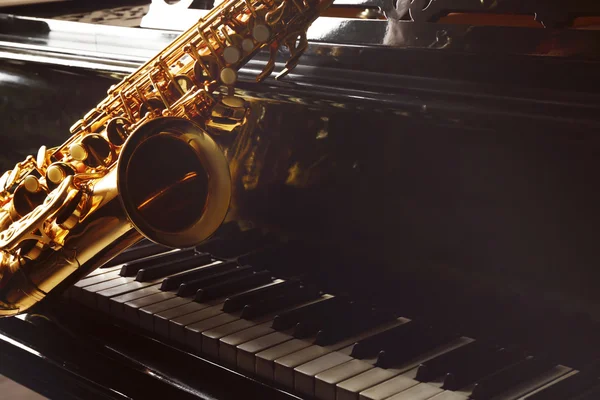 Саксофон, лежащий на пианино — стоковое фото