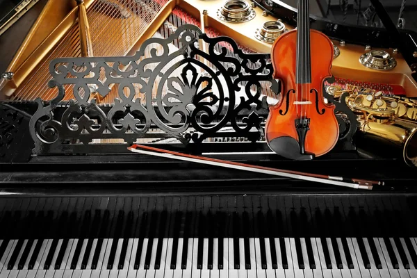 Βιολί και σαξόφωνο που βρίσκεται στο πιάνο — Φωτογραφία Αρχείου