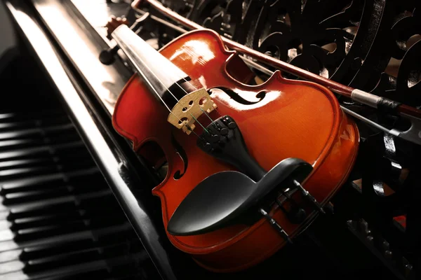 Violín acostado en el piano — Foto de Stock