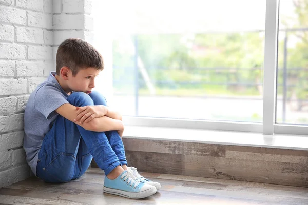 Sad boy sitting near window — Stock Photo, Image