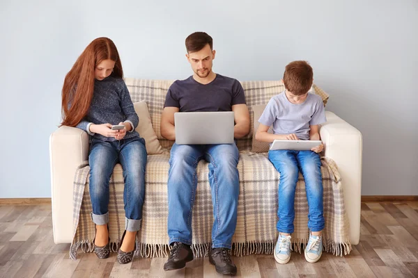 Concept de problèmes familiaux. Père, fille et fils assis sur le canapé avec des gadgets — Photo