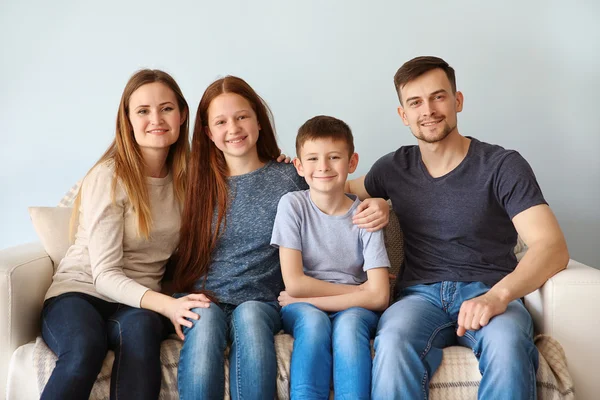 Happy family sitting on sofa — Stock Photo, Image