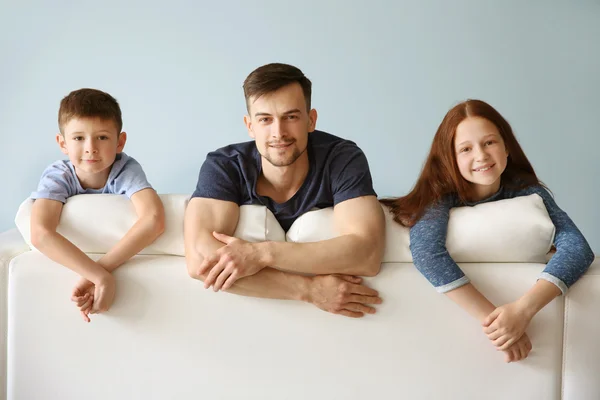 Happy family sitting on sofa — Stock Photo, Image