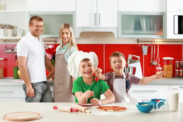 Счастливая семья делает пиццу — стоковое фото