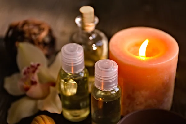 Olej spa w butelce z zapaloną świecą — Zdjęcie stockowe