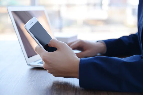 Człowiek za pomocą laptopa i inteligentny telefon — Zdjęcie stockowe