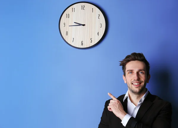Homme debout à côté d'une grande horloge — Photo
