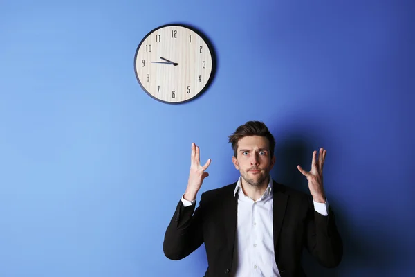 Homme debout à côté d'une grande horloge — Photo