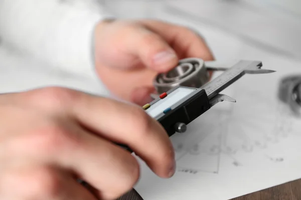 Mannelijke handen meten metalen detail — Stockfoto