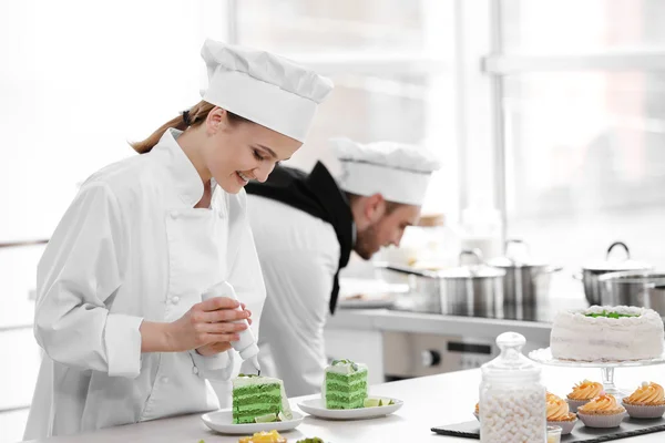 Mannelijke en vrouwelijke chef-koks werken — Stockfoto
