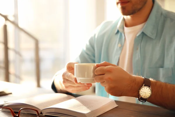 Mladý Muž Čtení Knih Pití Kávy Tabulce — Stock fotografie