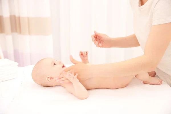 Madre manos aplicar crema en el bebé después de bañarse en la habitación — Foto de Stock