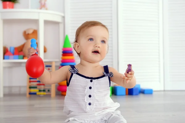 Lindo bebê brincando com brinquedos no quarto — Fotografia de Stock