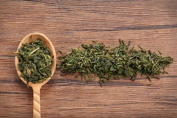 Dry tea leaves in wooden spoon — Stock Photo, Image