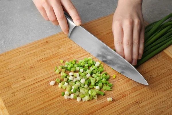 Hände schneiden frische grüne Zwiebeln — Stockfoto