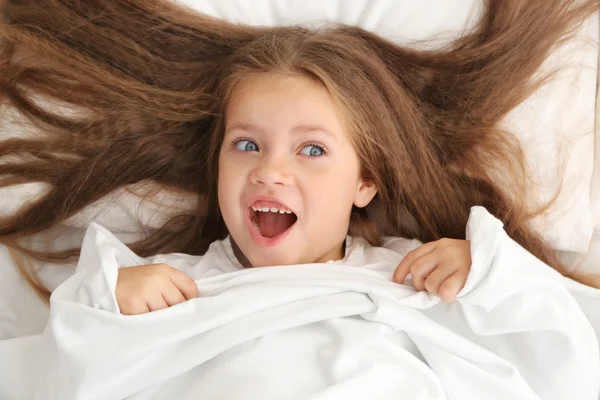 Schattig klein meisje onder bed vel — Stockfoto