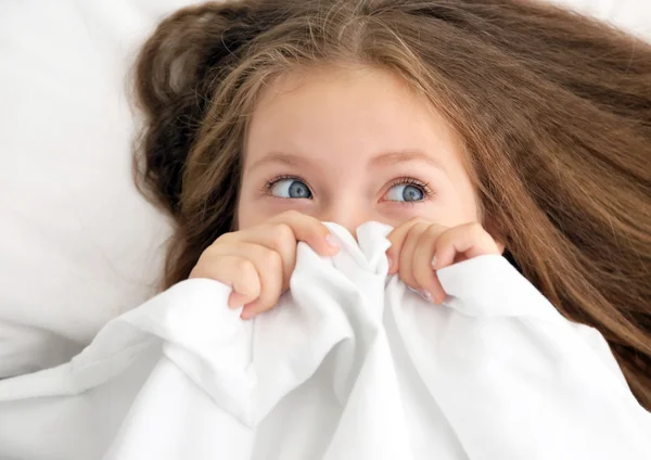 Schattig klein meisje onder bed vel — Stockfoto