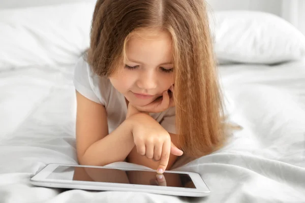Tablet ile oynayan sevimli küçük kız — Stok fotoğraf