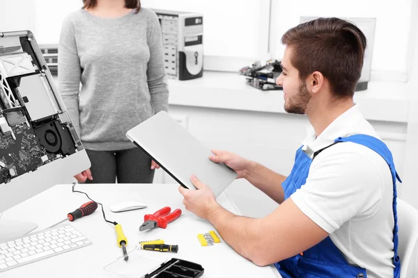 Young repairer getting broken laptop in service center — Stock Photo, Image