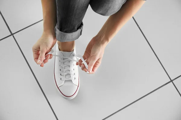 Женщина завязывает спортивную обувь — стоковое фото