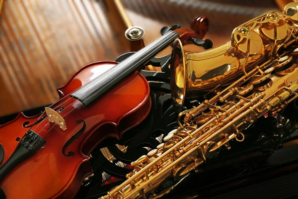 Violín y saxofón tumbados en el piano —  Fotos de Stock